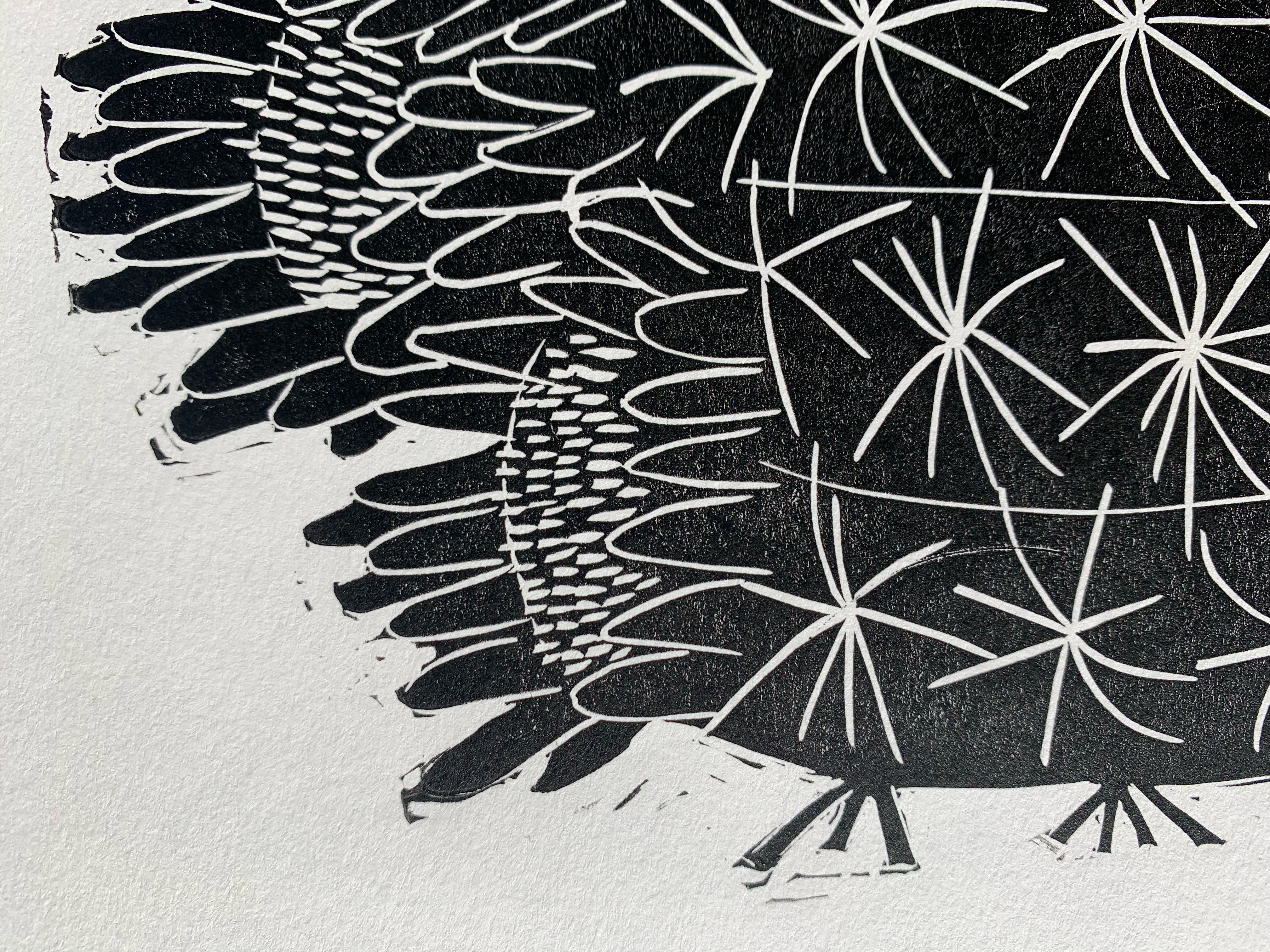 Detailed view of block print of barrel cactus on white paper in black ink.