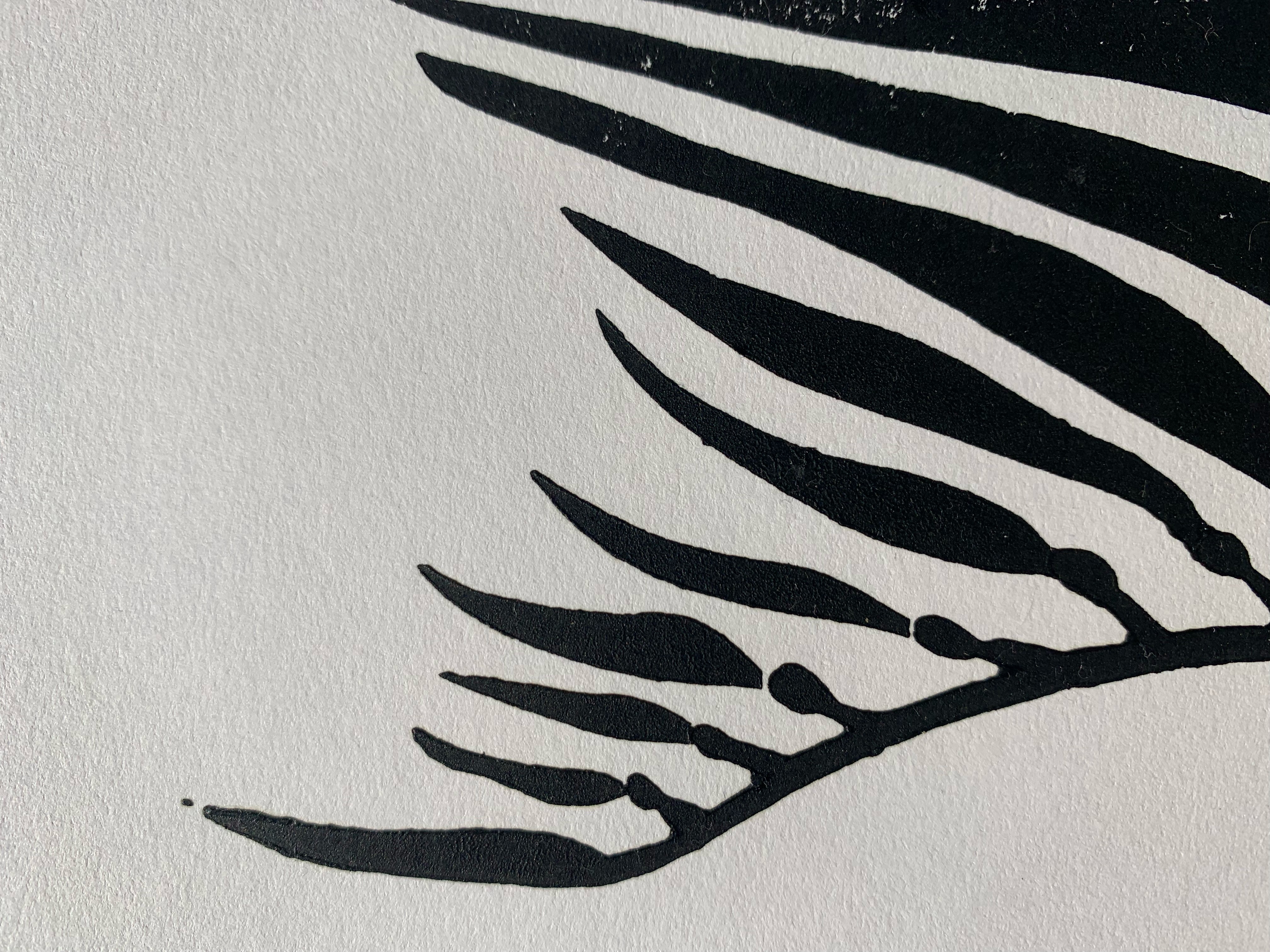 Detail of block print of giant kelp in black ink on white paper.